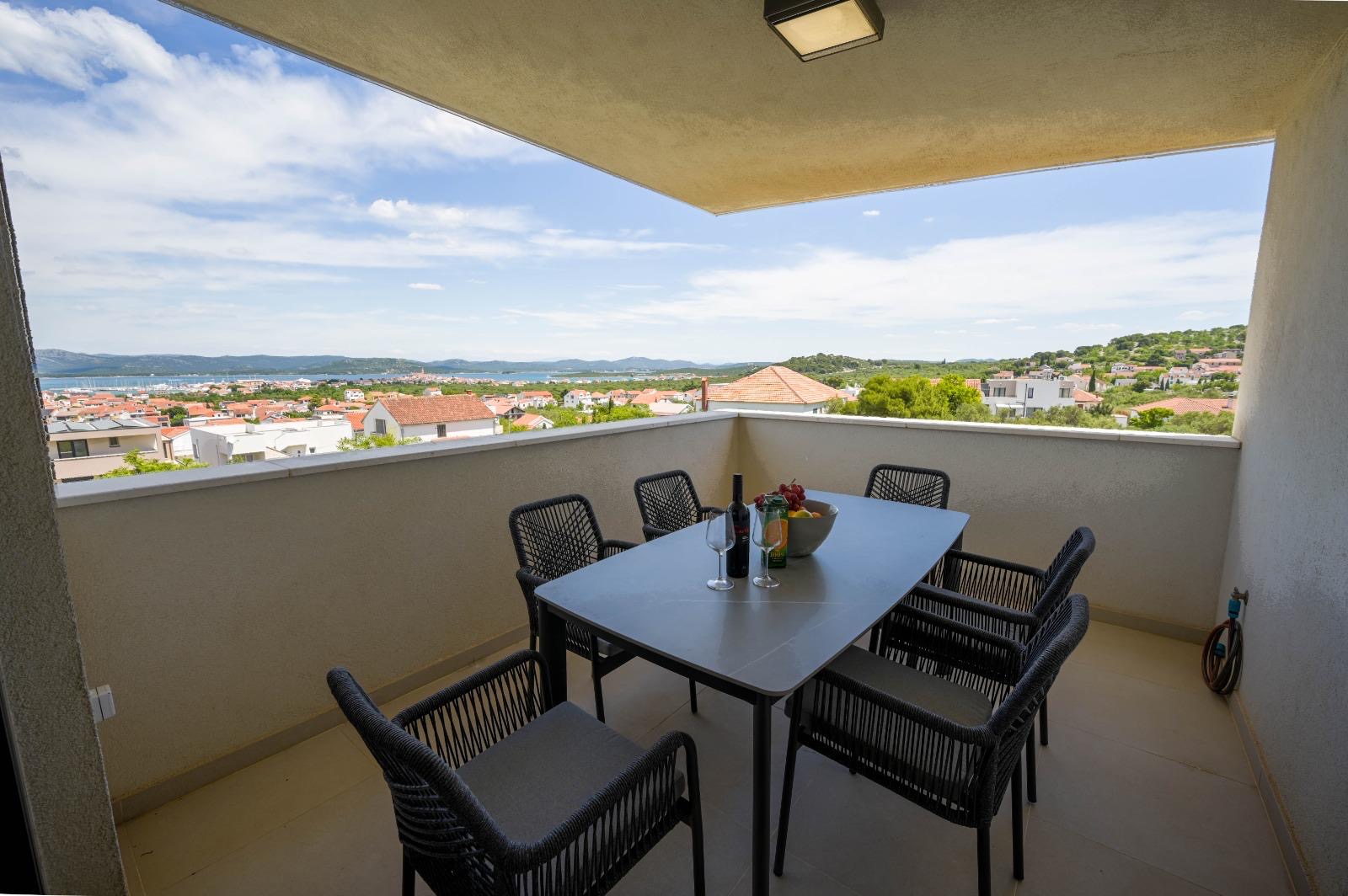 Covered dining terrace with a coastal view